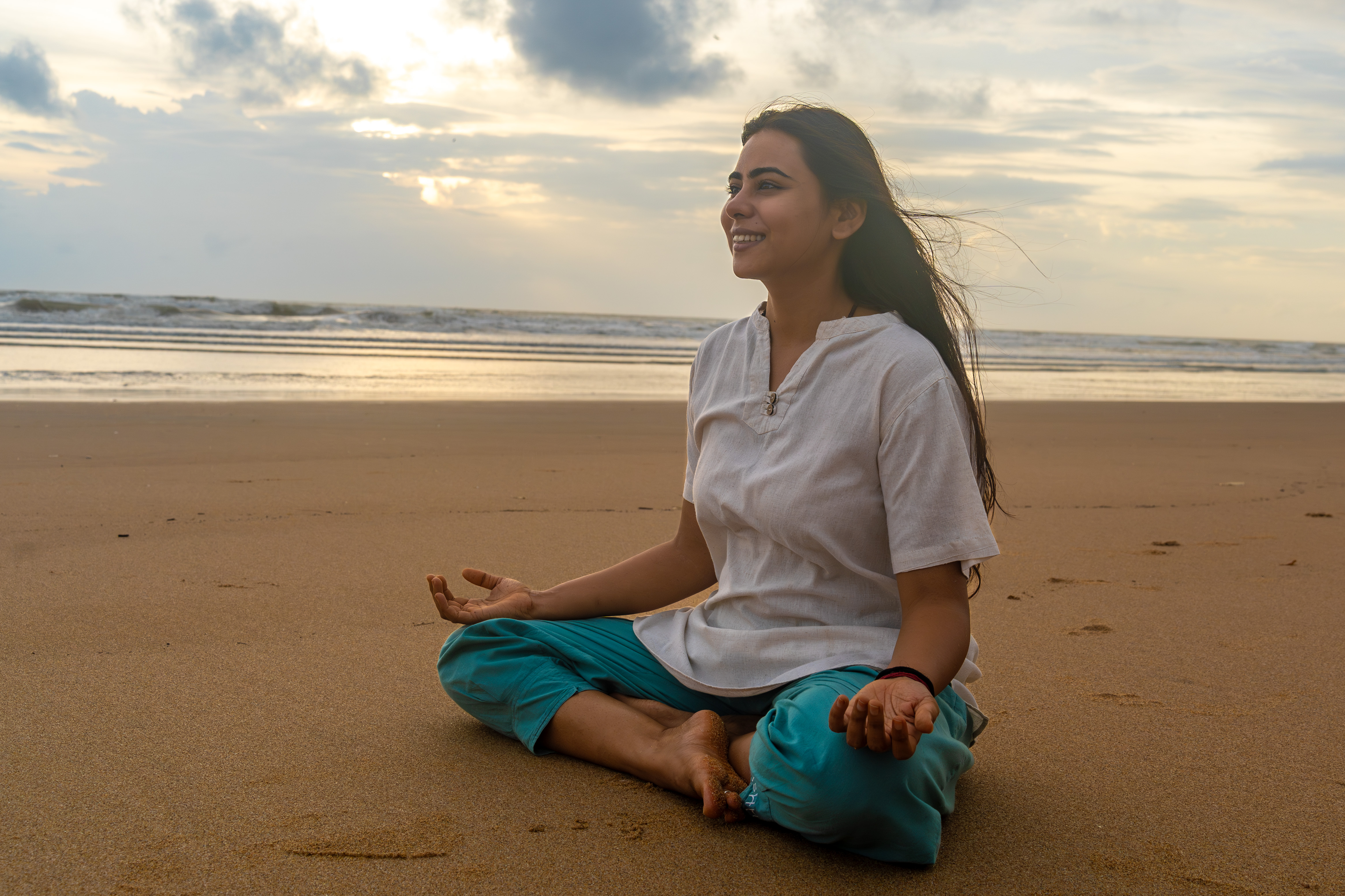 Astha meditating by the sea